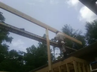 Carpenter setting a ridge beam over a new addition frame — Ice Dam Removal by Roofing Brothers in Centerville