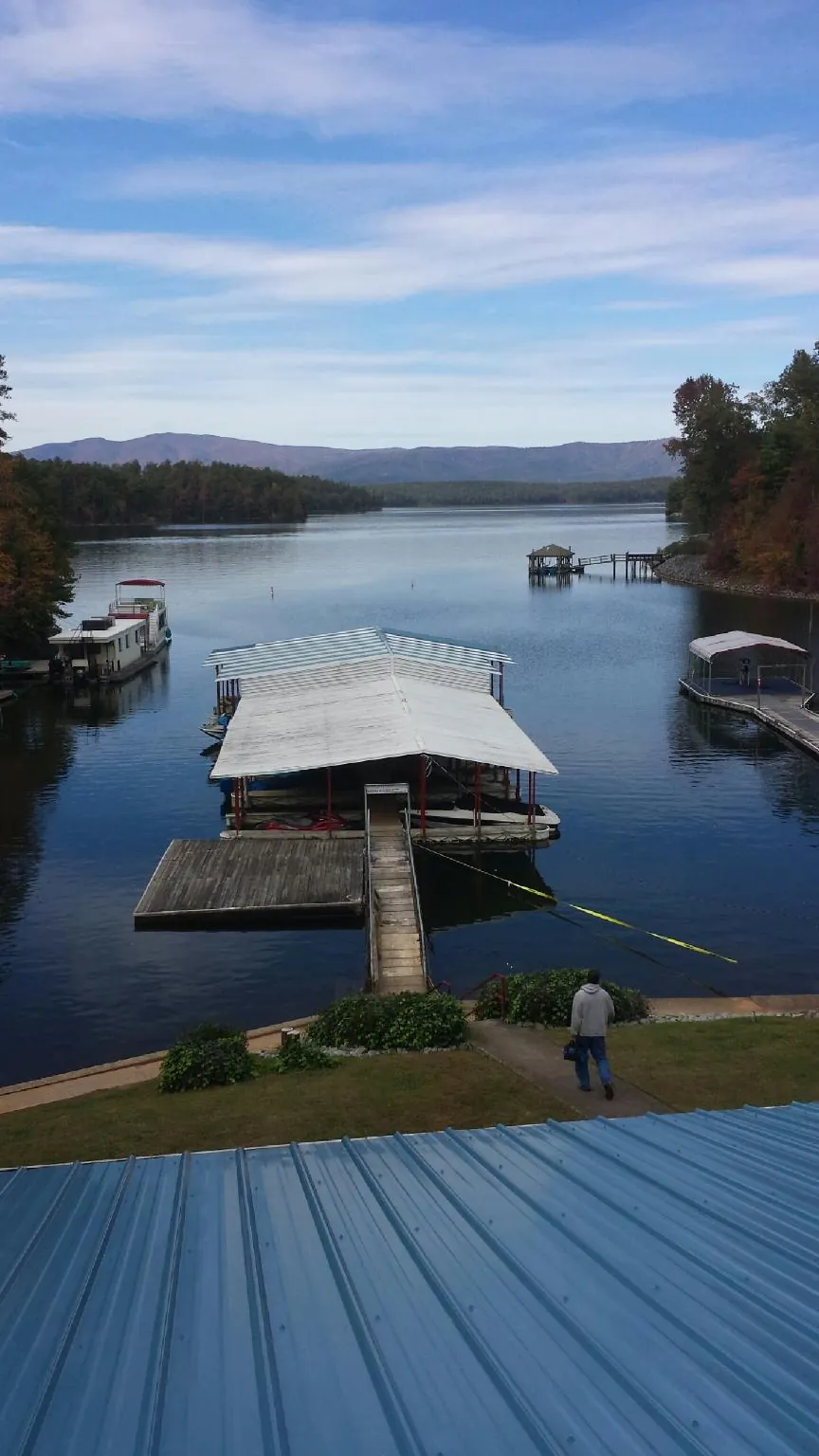 View across a lake from a newly installed blue metal roof in Centerville